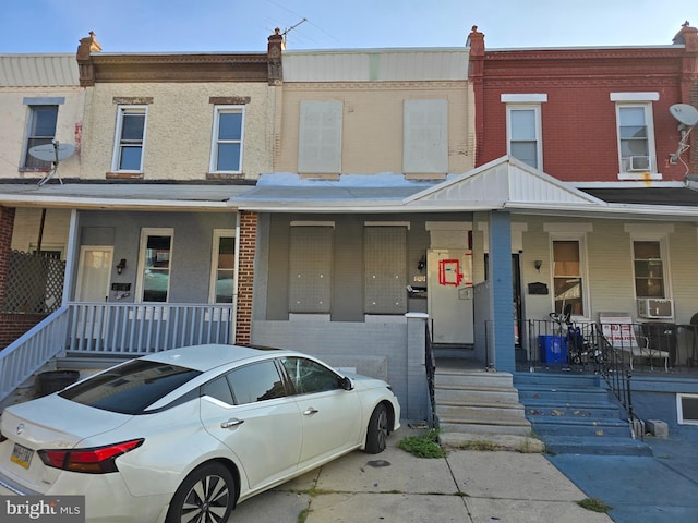 townhome / multi-family property featuring cooling unit and a porch