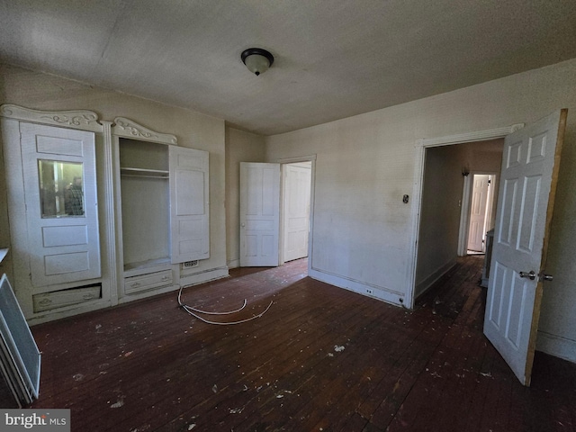 unfurnished bedroom with a closet and dark hardwood / wood-style floors