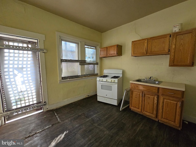 kitchen featuring dark hardwood / wood-style floors, sink, and white gas range oven