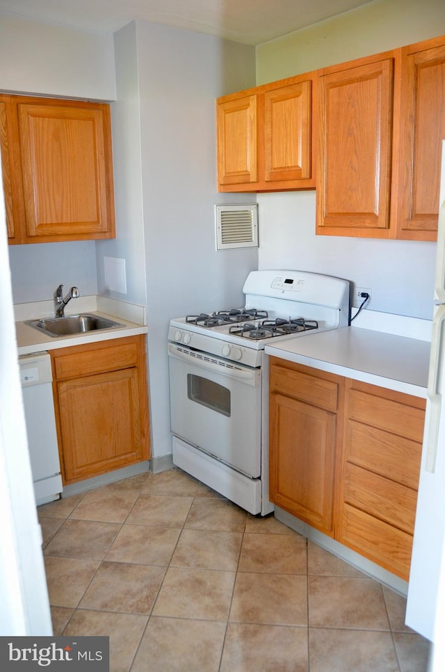 kitchen featuring sink, light tile patterned floors, and white appliances