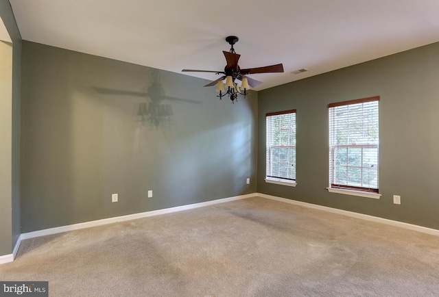 carpeted spare room featuring ceiling fan