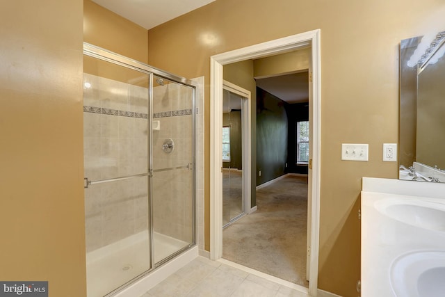 bathroom with tile patterned floors, a shower with door, and vanity