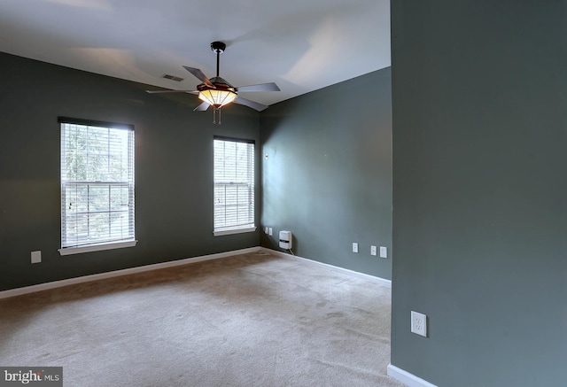 carpeted spare room featuring ceiling fan