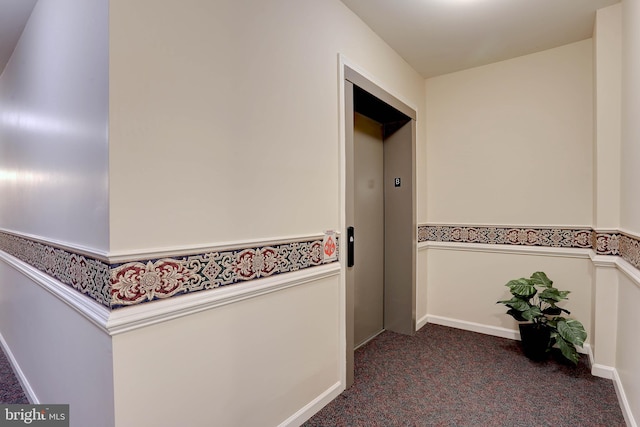 corridor featuring dark colored carpet and elevator