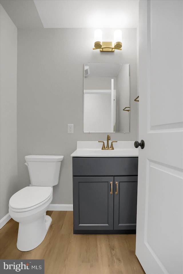 bathroom featuring hardwood / wood-style floors, vanity, and toilet