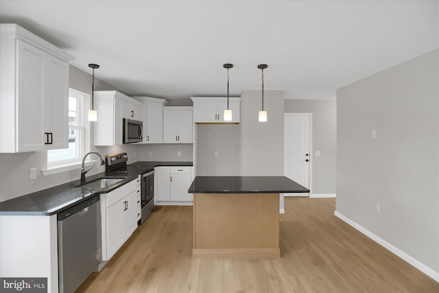 kitchen featuring white cabinets, appliances with stainless steel finishes, a kitchen island, and sink