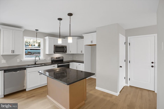 kitchen featuring a kitchen island, sink, white cabinetry, and stainless steel appliances