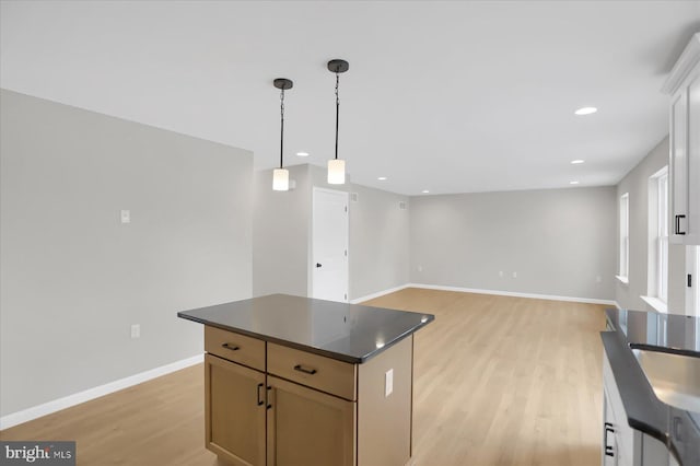 kitchen featuring a center island, pendant lighting, and light wood-type flooring