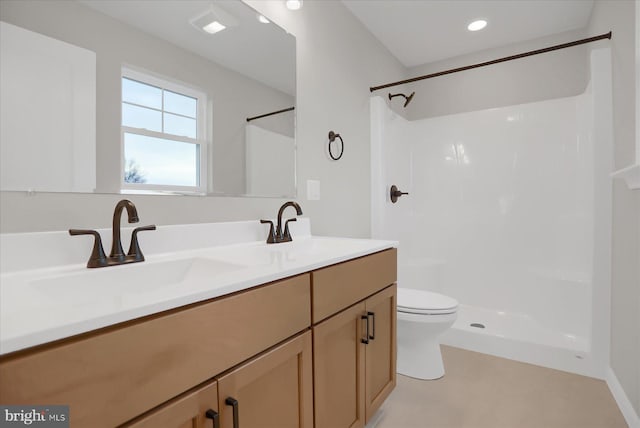 bathroom with vanity, toilet, and a shower