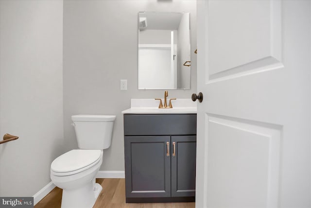 bathroom with hardwood / wood-style floors, vanity, and toilet