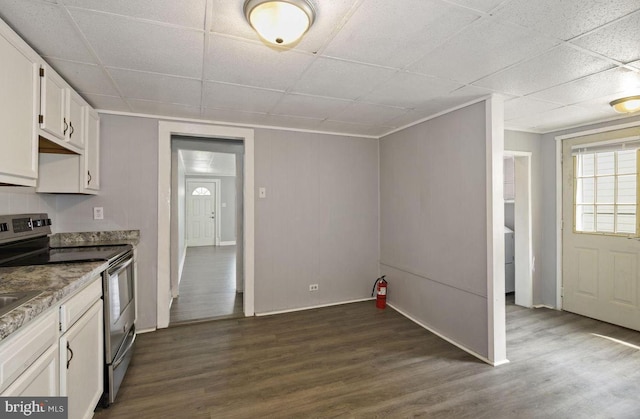 kitchen featuring a drop ceiling, white cabinetry, dark hardwood / wood-style flooring, and electric range