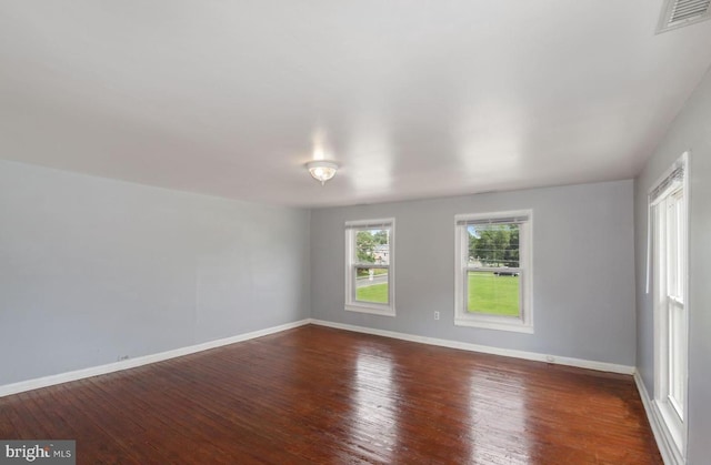 unfurnished room with dark hardwood / wood-style flooring