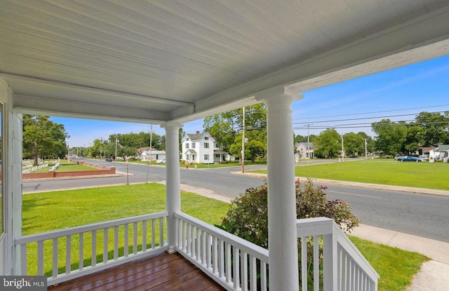 wooden deck with a lawn and a porch