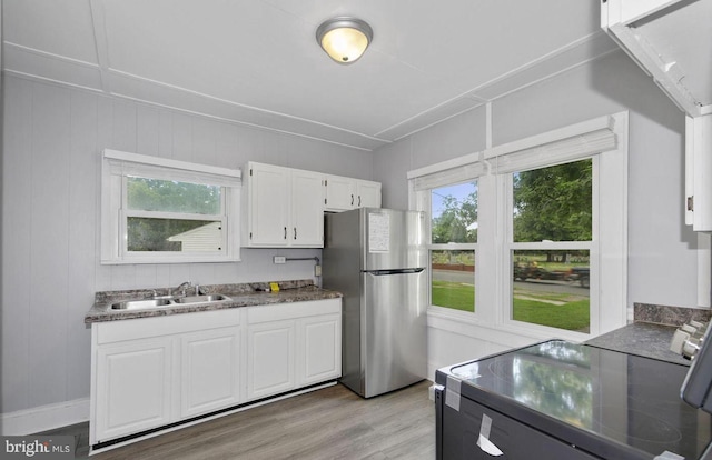 kitchen with white cabinets, a wealth of natural light, sink, and stainless steel refrigerator