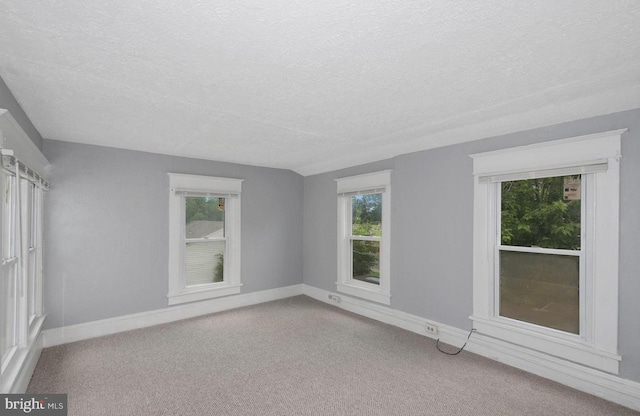 carpeted empty room with a textured ceiling