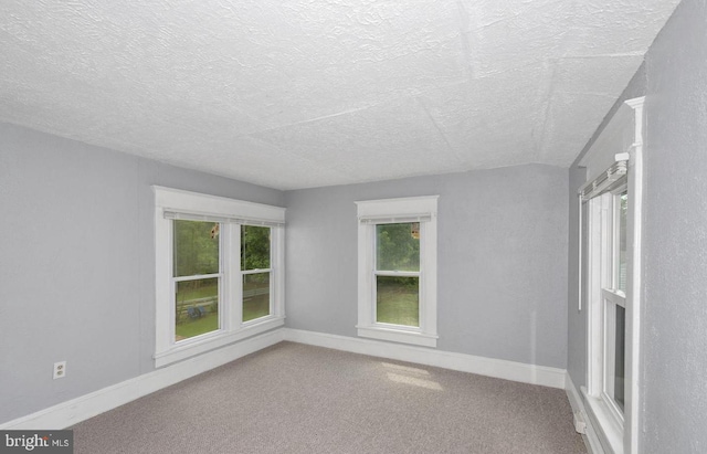 carpeted empty room with a textured ceiling