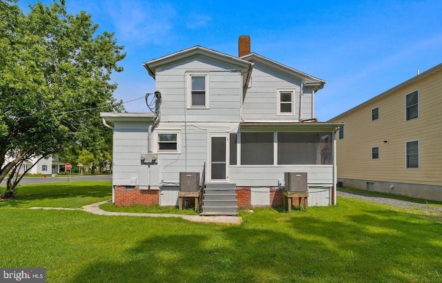 back of house featuring a sunroom and a lawn