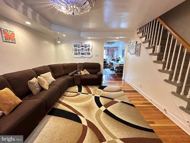 living room featuring a tray ceiling, hardwood / wood-style floors, and crown molding