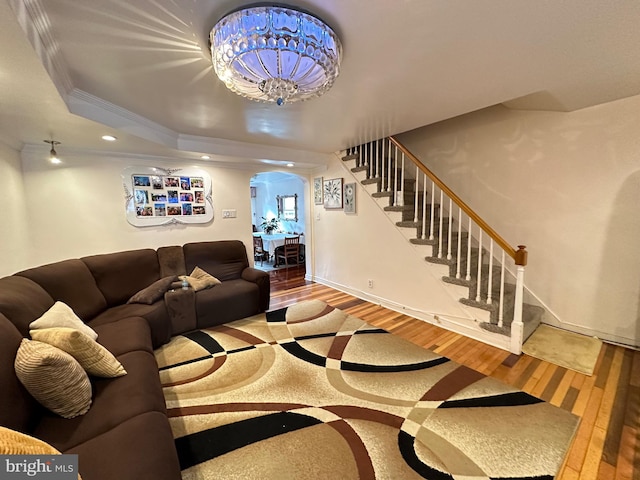 living room with a tray ceiling, crown molding, and hardwood / wood-style floors