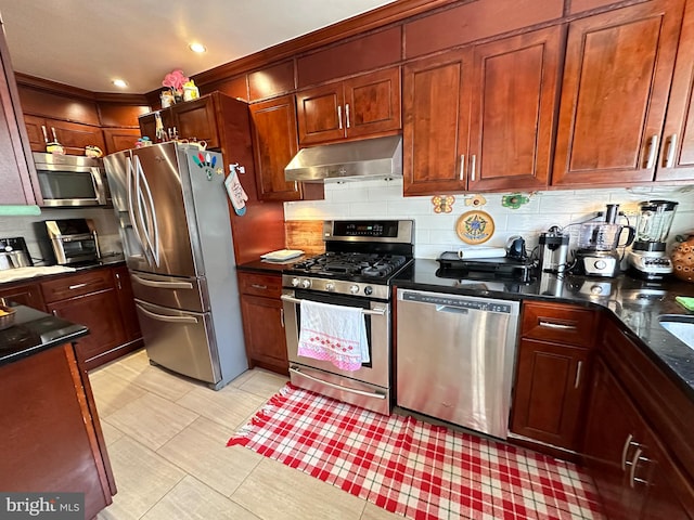 kitchen featuring dark stone counters, stainless steel appliances, and tasteful backsplash