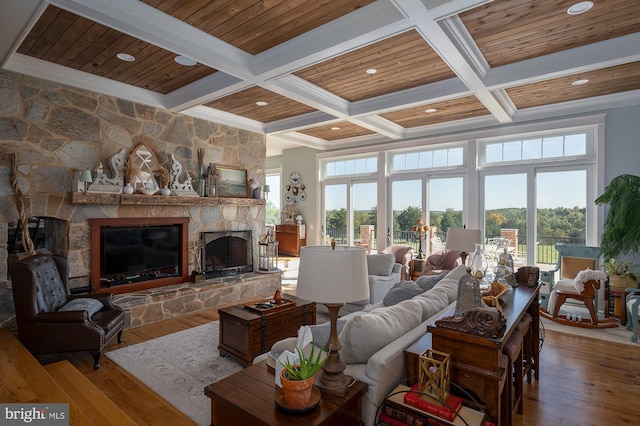 living room featuring beam ceiling, a wealth of natural light, a fireplace, and hardwood / wood-style floors