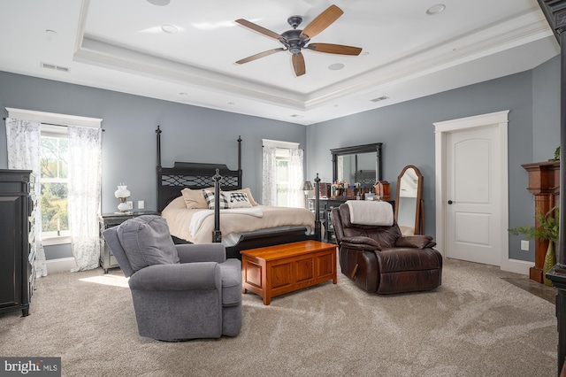 bedroom with crown molding, ceiling fan, light carpet, and a raised ceiling