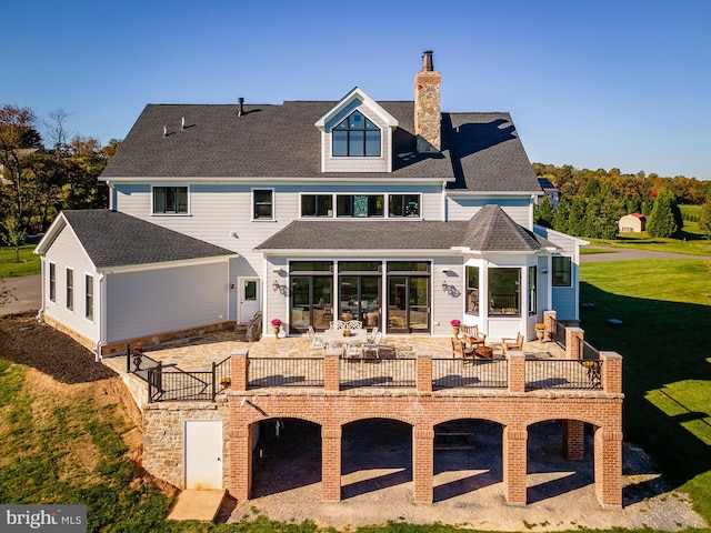 rear view of property featuring a patio, outdoor lounge area, and a yard