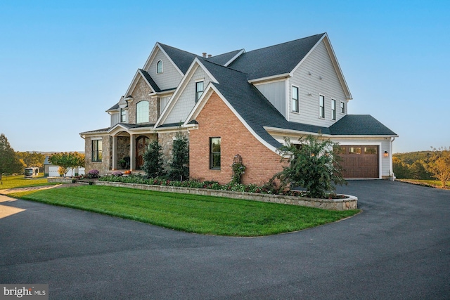 view of front of house featuring aphalt driveway, brick siding, roof with shingles, stone siding, and a front lawn