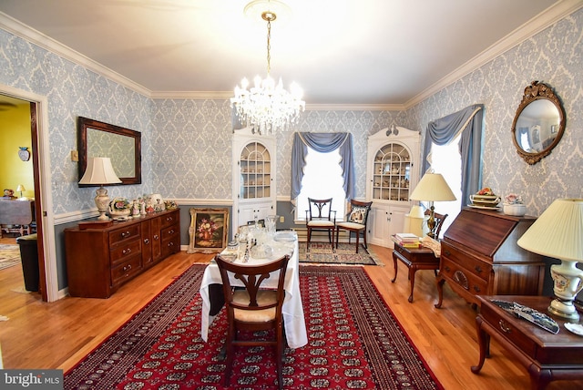 sitting room featuring wood-type flooring, a notable chandelier, and ornamental molding