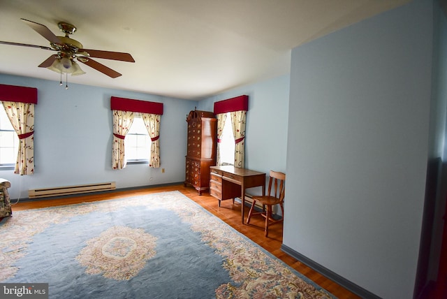 interior space with wood-type flooring, ceiling fan, and baseboard heating