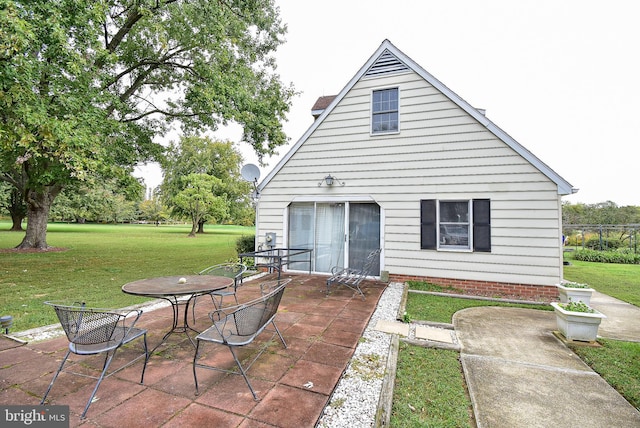 rear view of house featuring a lawn and a patio area