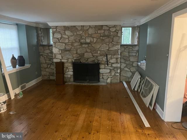 unfurnished living room with a fireplace, crown molding, and hardwood / wood-style floors