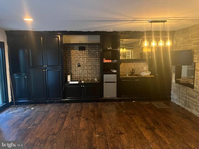 bar with pendant lighting, dark hardwood / wood-style floors, and sink