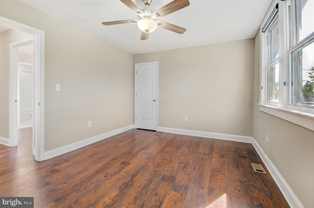 spare room with ceiling fan and dark hardwood / wood-style flooring