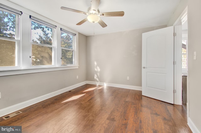 empty room featuring dark wood-type flooring and ceiling fan