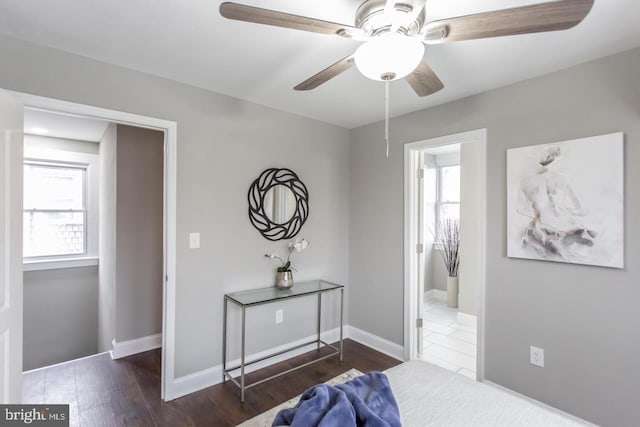 bedroom with dark hardwood / wood-style flooring, multiple windows, and ceiling fan