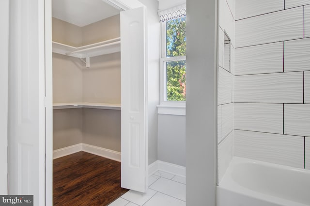 interior space featuring hardwood / wood-style flooring and shower / tub combination