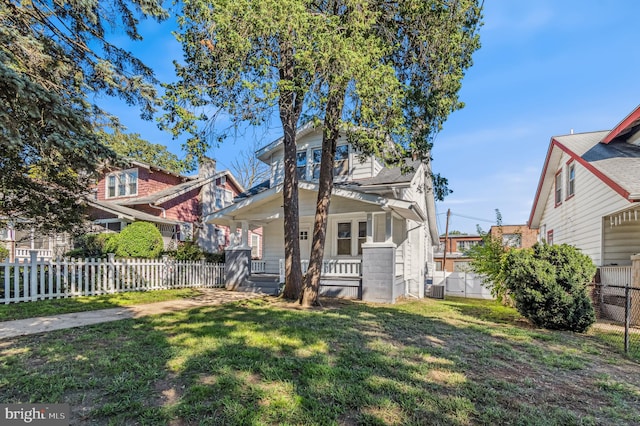 view of front of house featuring cooling unit and a front yard