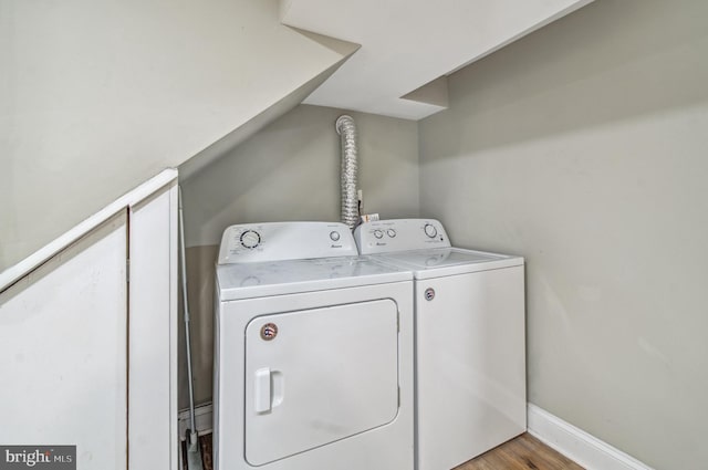 laundry room with washing machine and dryer and light wood-type flooring