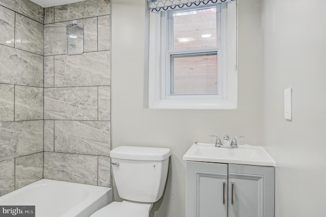 full bathroom featuring tiled shower / bath combo, vanity, and toilet