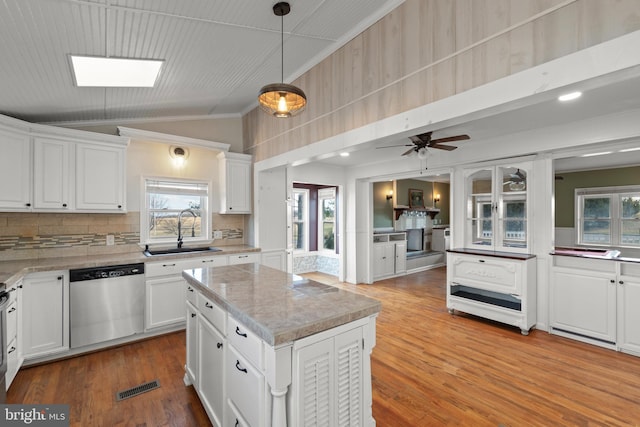 kitchen with white cabinetry, stainless steel dishwasher, a center island, and sink