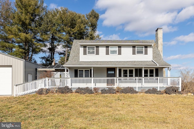 view of front of property featuring a garage, a front lawn, and covered porch