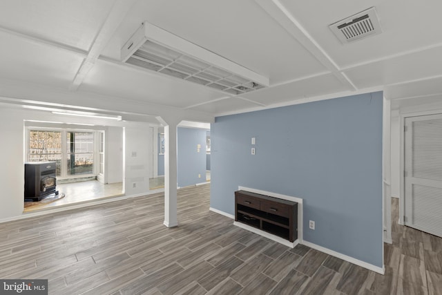 unfurnished living room with wood-type flooring and a wood stove