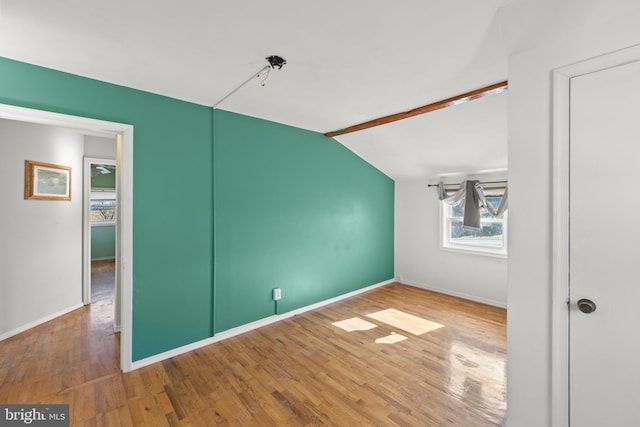 interior space featuring hardwood / wood-style flooring and lofted ceiling with beams