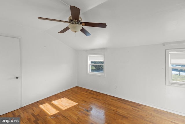 additional living space with hardwood / wood-style flooring, lofted ceiling, and a healthy amount of sunlight