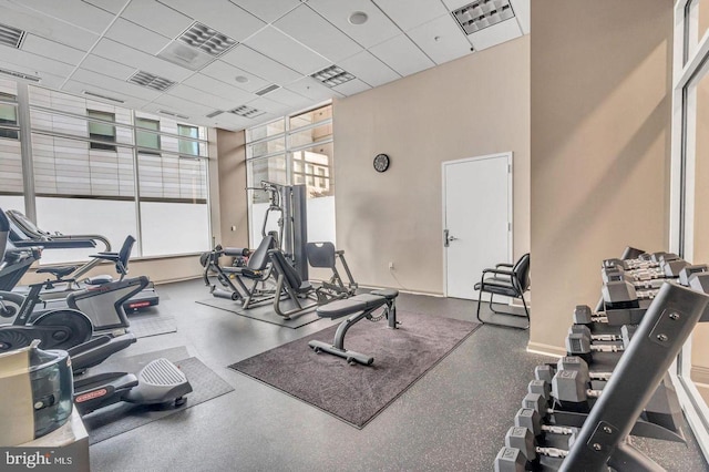 gym featuring a paneled ceiling and expansive windows