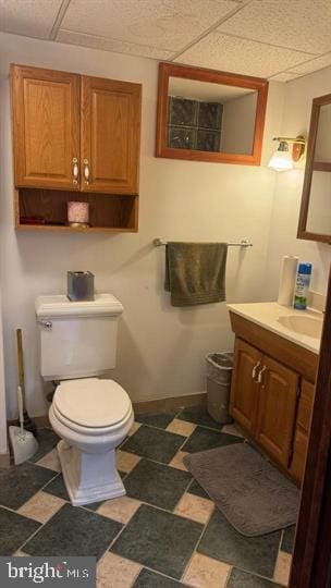 bathroom featuring a paneled ceiling, vanity, and toilet