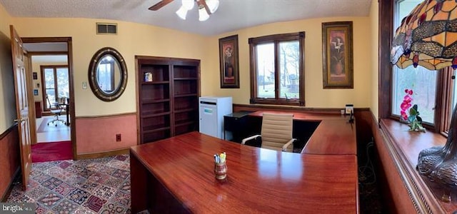 office with a textured ceiling, lofted ceiling, and ceiling fan