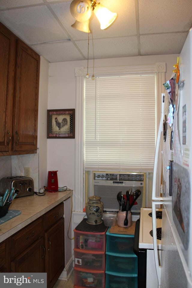 kitchen with a drop ceiling, white range, and ceiling fan