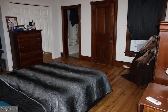 bedroom with cooling unit and hardwood / wood-style floors